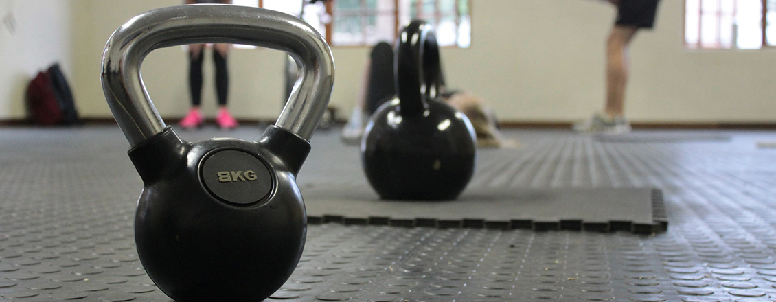 gray kettle dumbbells sitting on floor
