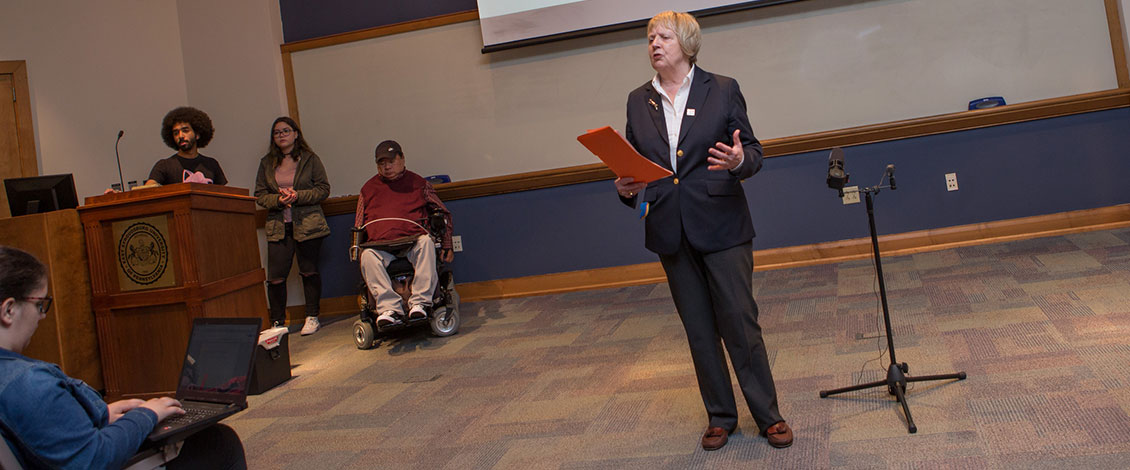 The provost speaking to an audience at the start of a colloquium