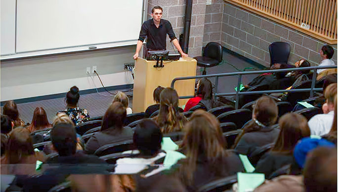 student standing a podium giving presentation