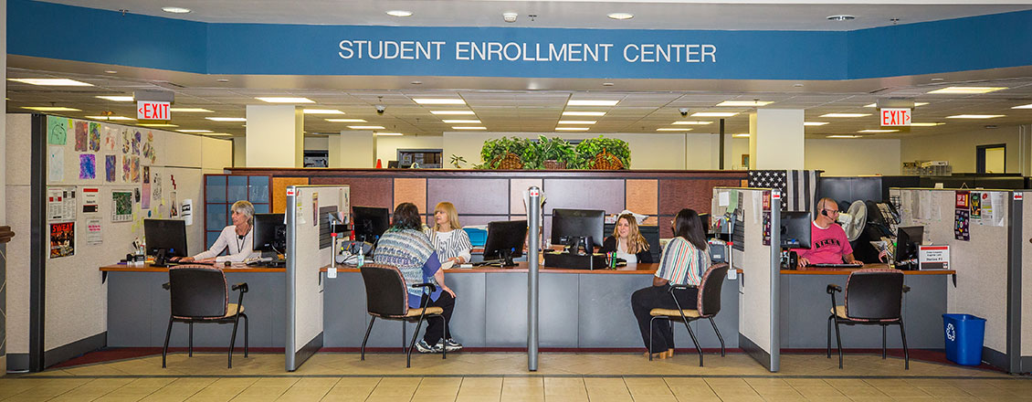 Enrollment Center front desk, students being assisted