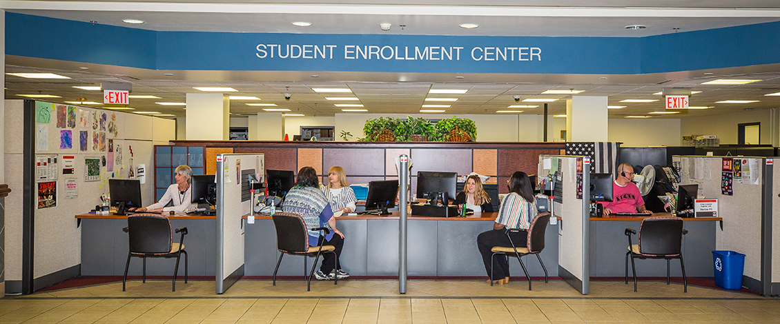 Enrollment Center front desk, students being assisted
