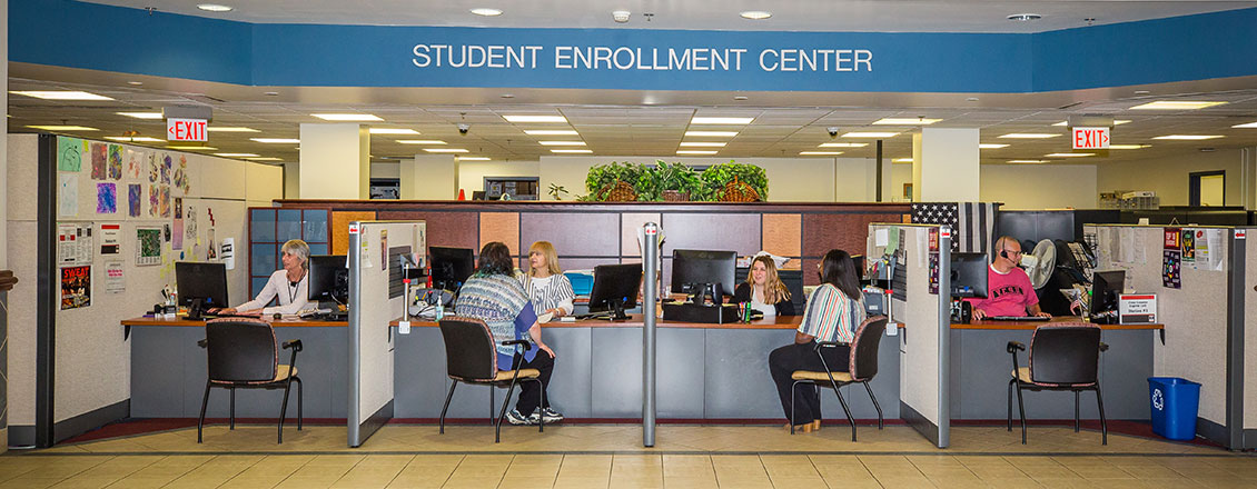 Enrollment Center front desk, students being assisted