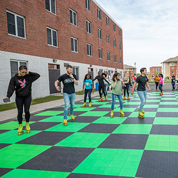 students roller skating in parking lot behind zimbar.