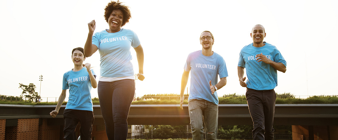 Volunteer people running in a field