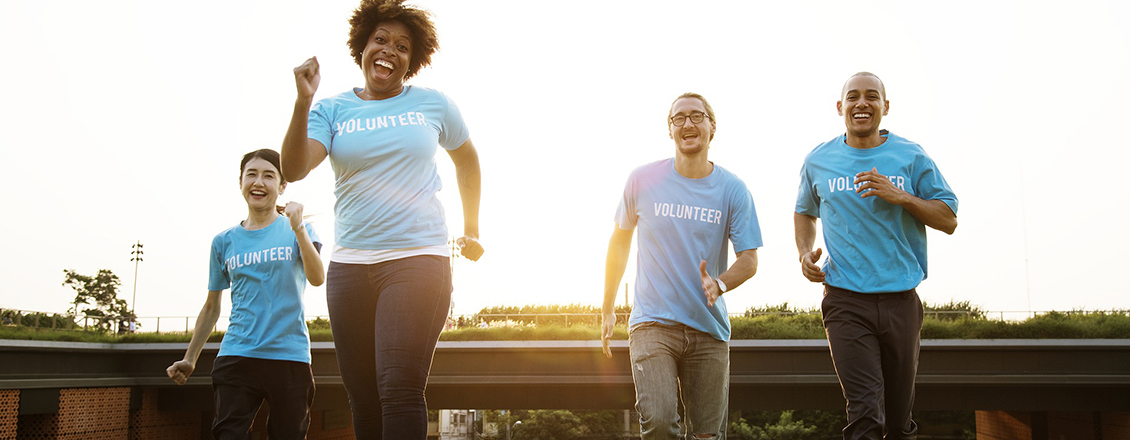 Volunteer people running in a field