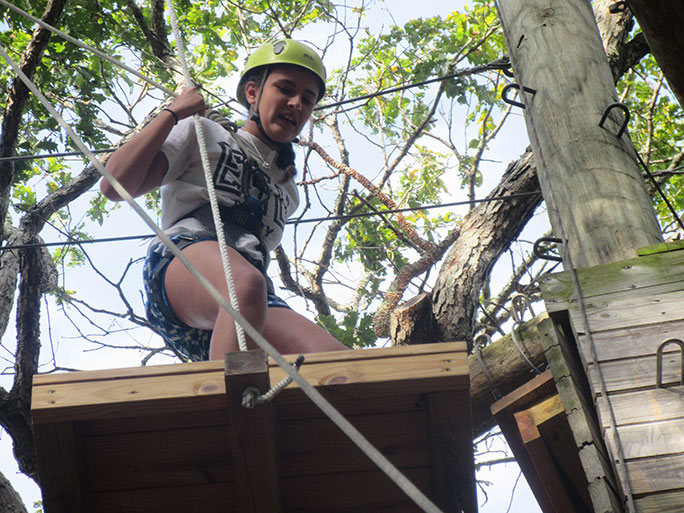 female student repelling from trees
