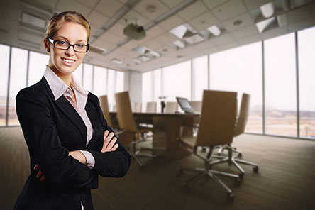blond female in business suite standing with arms folded