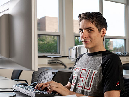 A male student types in a computer lab