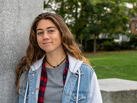 A female student standing near a sculpture