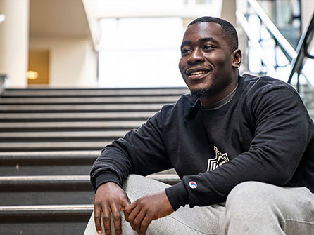 A male student sitting on steps