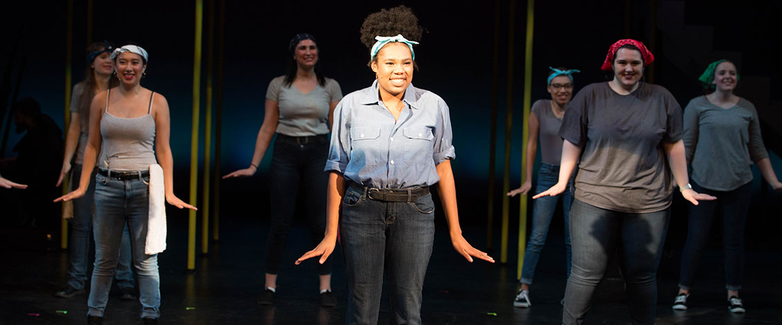 Actors pose on a stage in a performance