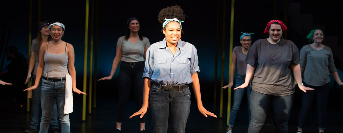 Actors pose on a stage in a performance