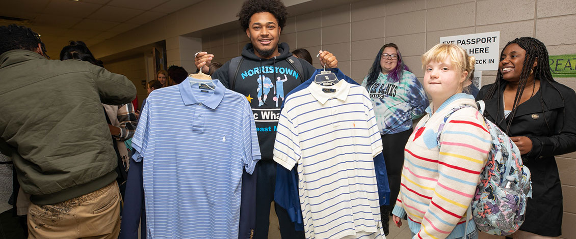 student holding up new shirts