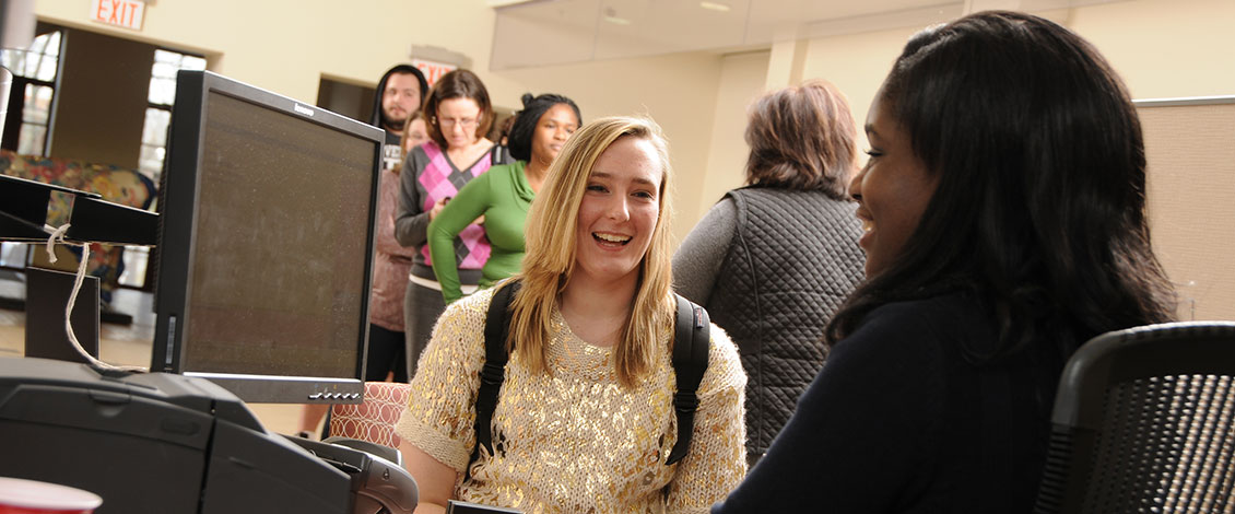 A staff member assists a student at the Student Enrollment Center