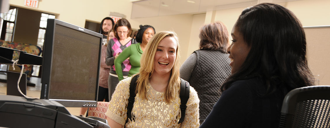 A staff member assists a student at the Student Enrollment Center