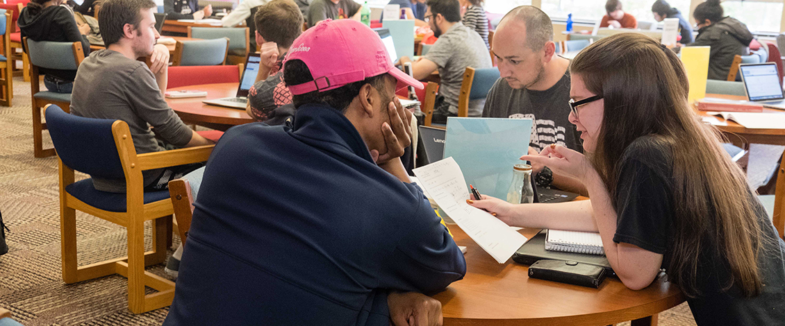 Students sitting at table in tutoring center getting help