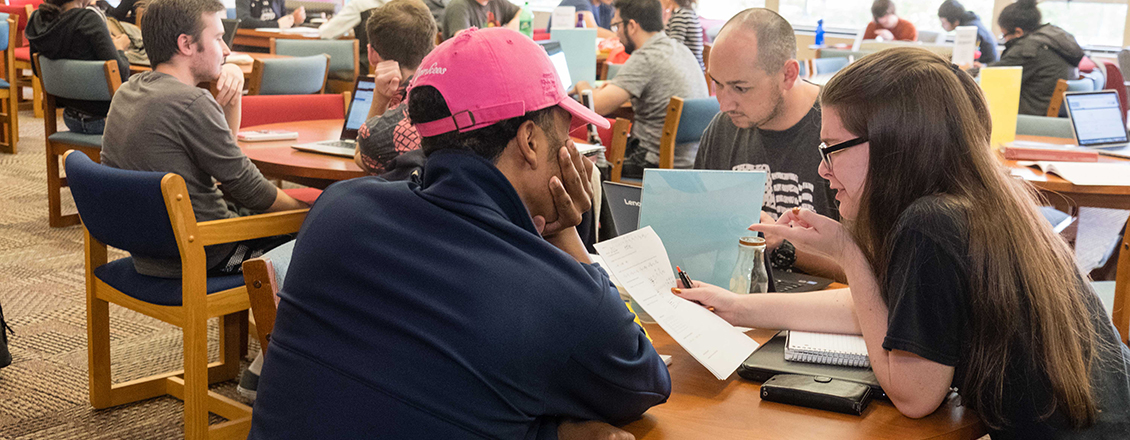 Students sitting at table in tutoring center getting help