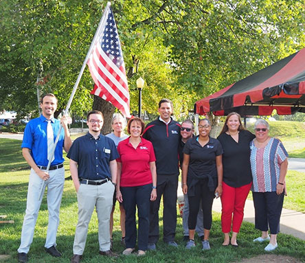 A group of ESU staff outside holding the American flag