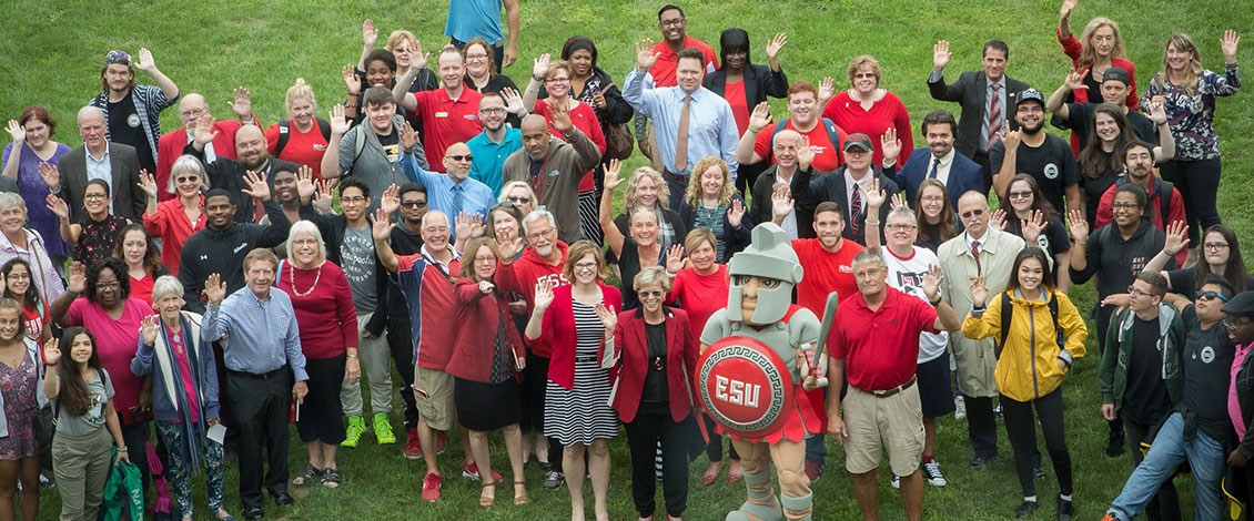 A large group of staff, students and faculty on a lawn